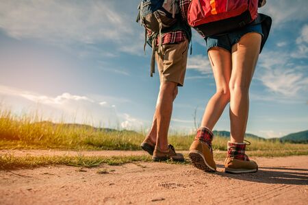Hikers with backpacks walking trough forest path wearing mountain boots with focus on the shoes.の写真素材