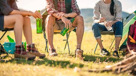  group of tourists clinking beer bottles in camping.adventure, travel, tourism, friendship and people concept.の写真素材