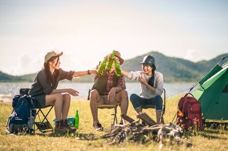 group of tourists clinking beer bottles in camping.adventure, travel, tourism, friendship and people concept.の写真素材