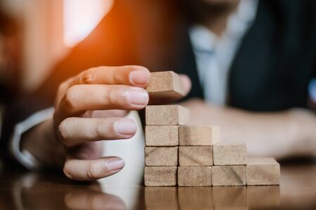 plan and strategy in business.risk concept.hand of man has piling up and stacking a wooden...