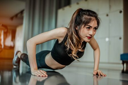 young woman doing push-ups at the gym.