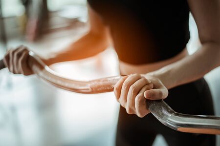 young fitness asian woman exercise with  barbells in gym for building muscles.exercising...