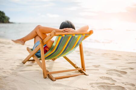 Woman relaxing on beach, looking at sea. Copy space.の写真素材