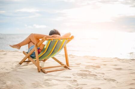 Woman relaxing on beach, looking at sea. Copy space.の写真素材