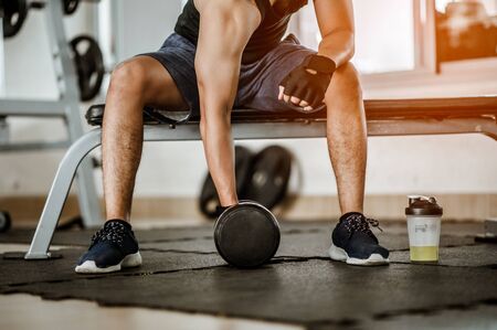Bodybuilder working out with dumbbell weights at the gym.man bodybuilder doing exercises with dumbbell. Fitness muscular body の写真素材