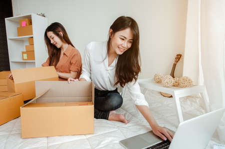 Young woman asian work from home online marketing packaging and delivery for customer at home. Business owner, SME, shipping, work from home(WFH), freelance, Start up concept.の写真素材