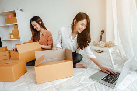 Young woman asian work from home online marketing packaging and delivery for customer at home. Business owner, SME, shipping, work from home(WFH), freelance, Start up concept.の写真素材