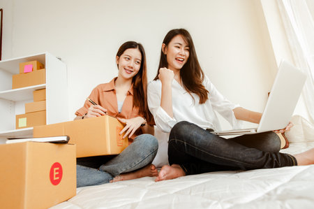 Young woman asian work from home talking with customers to sell products online and delivery for customer. Business owner, SME, shipping, work from home(WFH), freelance, Start up concept.の写真素材