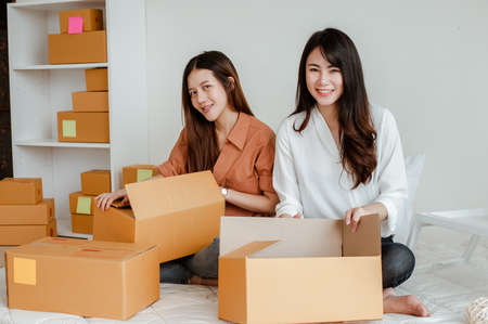 Young woman asian work from home online marketing packaging and delivery for customer at home. Business owner, SME, shipping, work from home(WFH), freelance, Start up concept.の写真素材