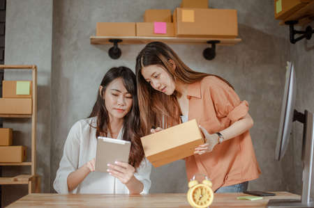 Young woman asian work from home online marketing packaging and delivery for customer at home. Business owner, SME, shipping, work from home(WFH), freelance, Start up concept.の写真素材