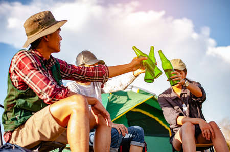 Team of asian climbers hiker are sitting and enjoying a drink after a set up outdoor tent in the forest path autumn season. Hiking, hiker, team, forest, camping , activity concept.の写真素材