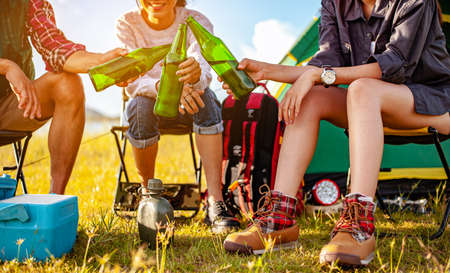 Team of asian climbers hiker are sitting and enjoying a drink after a set up outdoor tent in the forest path autumn season. Hiking, hiker, team, forest, camping , activity concept.の写真素材