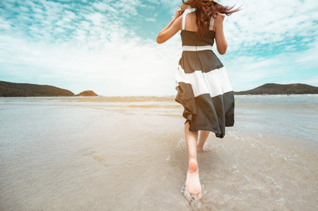 Happy asian women with holding hat running and jump joyfully enjoy life on the beach vacation. beach, summer, liftstyle, positive mood, travel, relax concept.の写真素材
