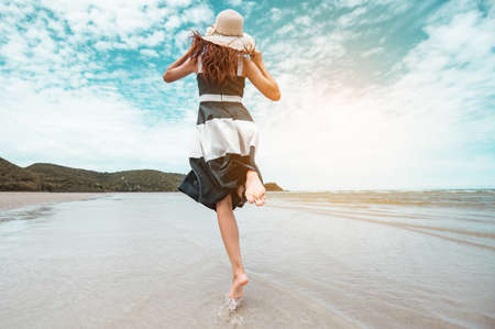 Happy asian women with holding hat running and jump joyfully enjoy life on the beach vacation. beach, summer, liftstyle, positive mood, travel, relax concept.の写真素材