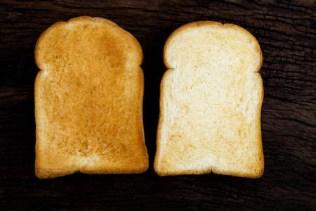 two toast bread slice isolated on rustic wood background close up, top view, breakfast food and drink concept.の写真素材
