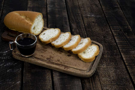 Espresso coffee and bread baguette slice on wood table isolated background closeup, top view,...