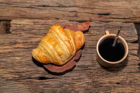 Espresso coffee and croissant in plate on isolated wood table background close up, top view, breakfast food and drink concept.の写真素材