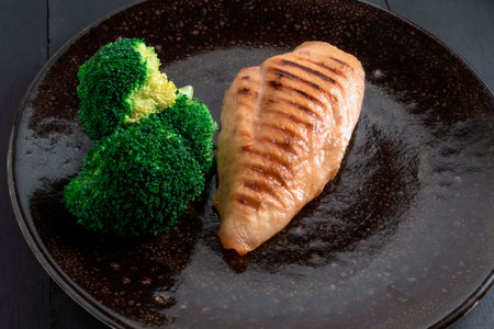 Grill chicken and broccoli in plate on black wood background, top view healthy food concept.の写真素材