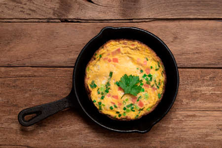 Omelet has carrot onion in pan isolated on wood background, top view, healthy breakfast food concept.の写真素材