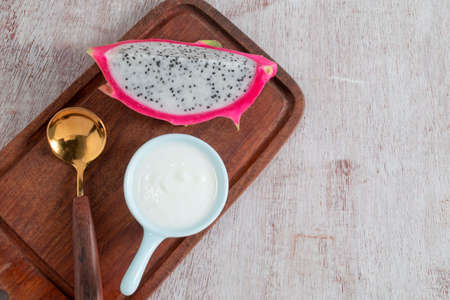 Yogurt in bowl has dragon fruit white wood background, top view, healthy food concept.の写真素材