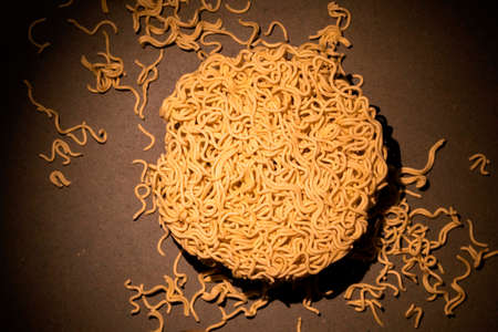 Yellow instant noodle isolated on green wood background, top view, Asian food concept.の写真素材