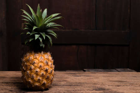 Pineapple isolated on wood background, top view, healthy fruit food concept.