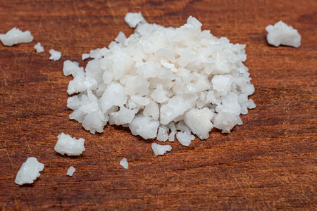 Dead sea salt pile isolated on wood background closeup, top view, food and drink concept.