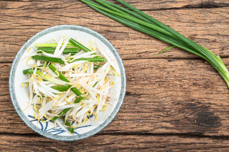 Stir Fried Bean Sprout in bowl on wood background close up, top view, vegetarian food concept.の写真素材