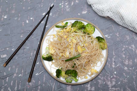 Fried chow mein Chinese noodles in plate on grey background close up, top view, healthy vegetarian food concept.の写真素材