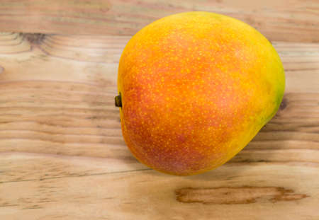 Mango fruit yellow isolated on wood background, top view, healthy food concept.