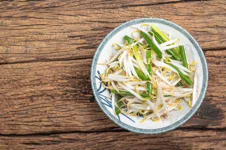 Stir Fried Bean Sprout in bowl on wood background close up, top view, vegetarian food concept.の写真素材