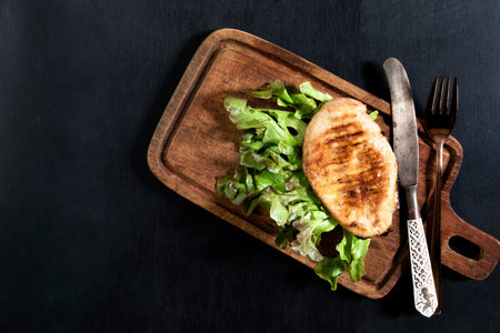 Grill chicken in cutting board on dark wood background top view, healthy food concept.の写真素材