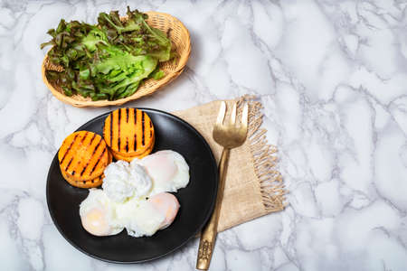 Egg poached has butternut squash lettuce in plate on marble table background top view, close up, breakfast food concept.の写真素材