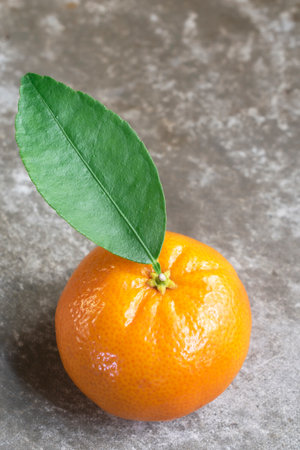 Orange fruit has leaves on stone background close up, top view, healthy food concept.の写真素材