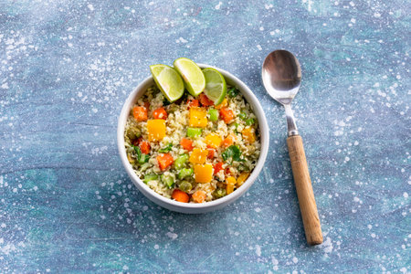 Cauliflower fried rice add carrot bean sweet pepper in white bowl on blue wood background, copy...