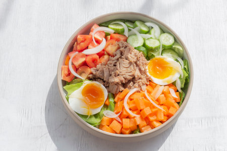 Tuna salad add egg in white bowl isolated on wood background close up, top view, healthy food concept.の写真素材