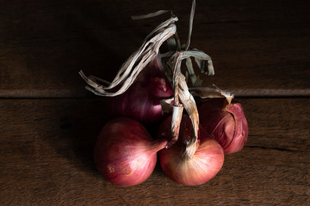 Shallot or red onion on dark wood table top view close up, herbal food concept.