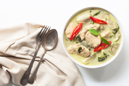 Green chicken curry has eggplant chill basil in bowl on white wood background, top view, Asian food concept.の写真素材