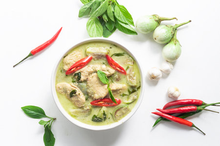 Green chicken curry has eggplant chill basil in bowl on white wood background, top view, Asian food concept.の写真素材