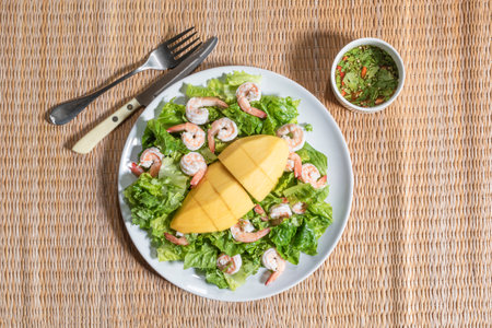 Shrimp salad has mango romaine lettuce in bowl seafood dressing on wood background top view, healthy food concept.の写真素材