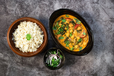 Chickpea curry with spinach has brown rice on black stale background, top view,  healthy vegan food concept.の写真素材