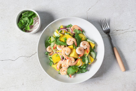 Shrimp salad has mango cucumber peppermint in bowl on slate background top view, healthy food concept.の写真素材