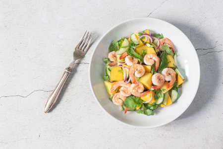 Shrimp salad has mango cucumber peppermint in bowl on slate background top view, healthy food concept.の写真素材