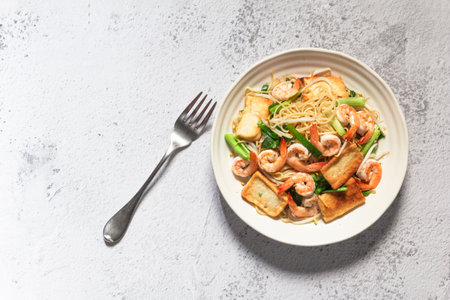 Stir fried chow mein Chinese noodles add shrimp tofu bean sprout in plate on slate background, top view, healthy food concept.の写真素材