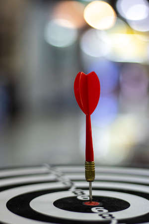 Close up shot red dart arrow on center of dartboard, metaphor to target success, winner conceptの写真素材
