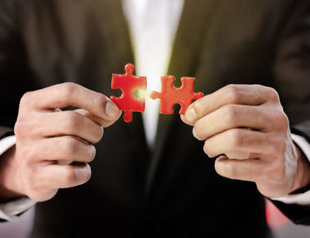 Businessman Hand connecting couple puzzle piece in office. Business solutions, target, successful,...