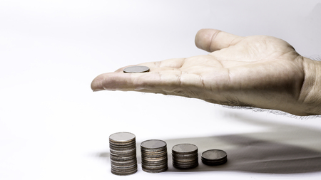 Hand hold coins for saving money concept, Row of stack of coin with copy space for create your text, Saving, Investment money concept, palm of hand with coin and stack of money on white backgroundの写真素材