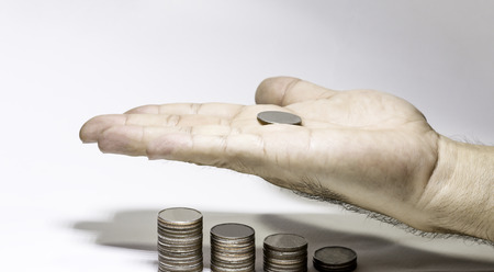 Hand hold coins for saving money concept, Row of stack of coin with copy space for create your text, Saving, Investment money concept, palm of hand with coin and stack of money on white backgroundの写真素材