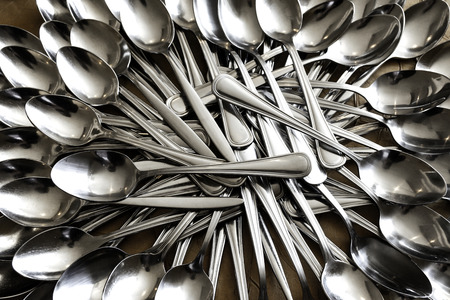 Stack of shining spoon, Abstract background of  sparkling bronze spoon, kitchen equipment, Row of silver spoon background, Glittering light from kitchen equipmentの写真素材