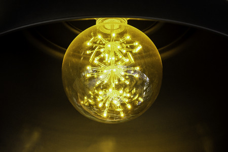 Close up incandescent lamp shining, Yellow light of lamp hang on ceiling